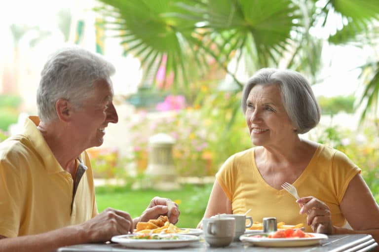 Senior couple eat outside