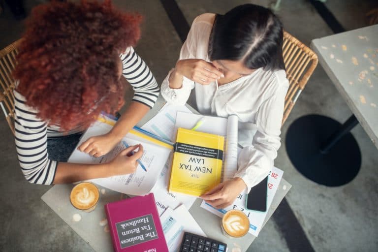 Top view of two entrepreneurs studying tax law
