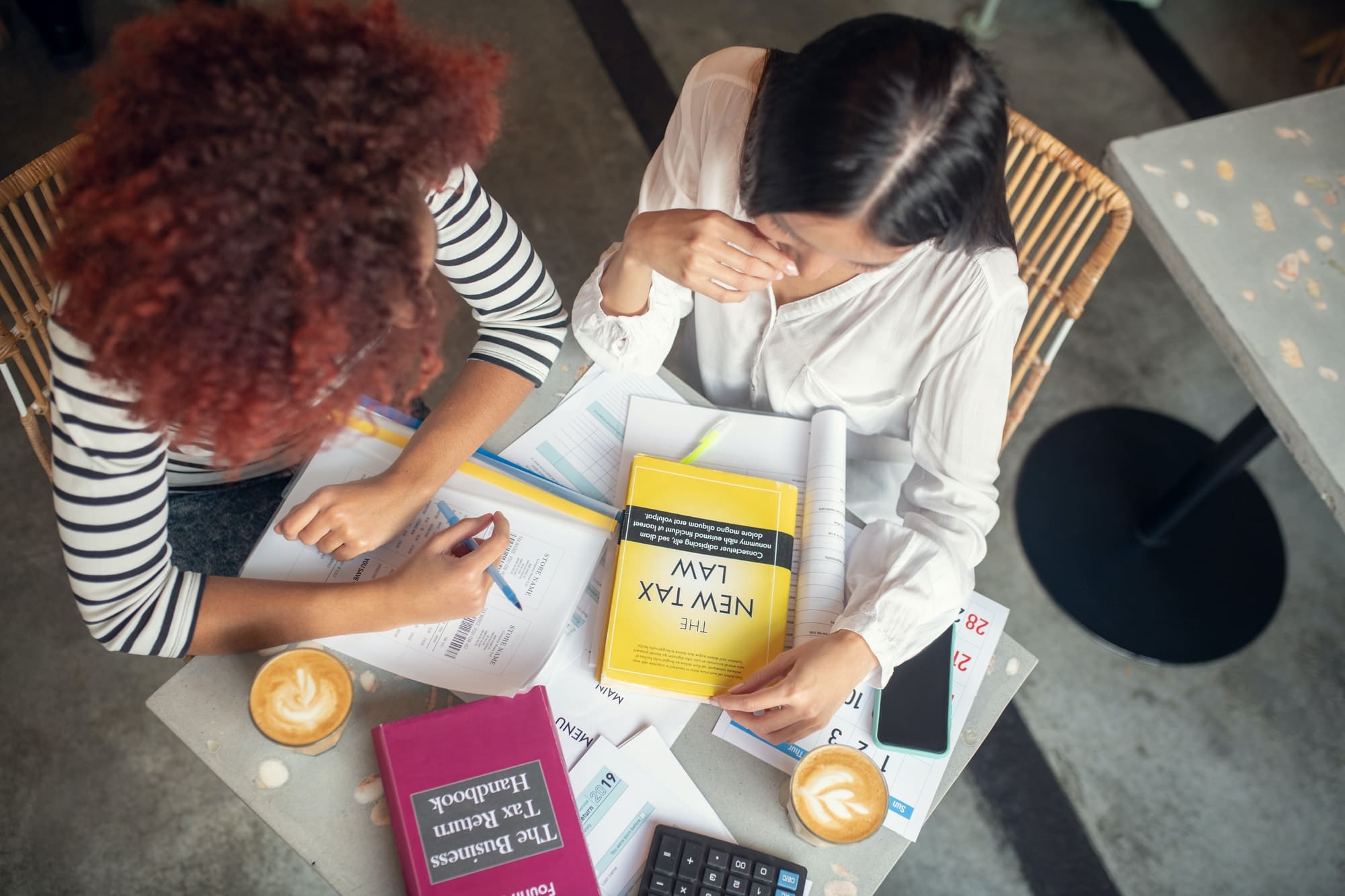 Top view of two entrepreneurs studying tax law